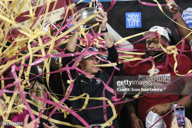 Florida State Seminoles head coach Mike Norvell holds up the trophy as the confetti flies during the ACC Football Championship Game between the...