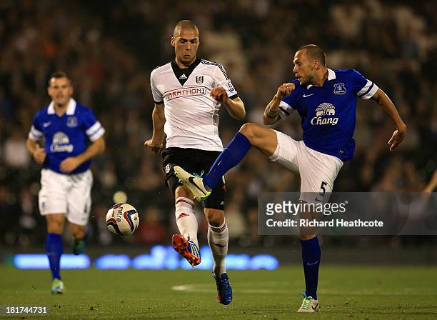 John Heitinga of Everton challenges Pajtim Kasami of Fulham during the Captial One Cup Third Round match between Fulham and Everton at Craven Cottage...