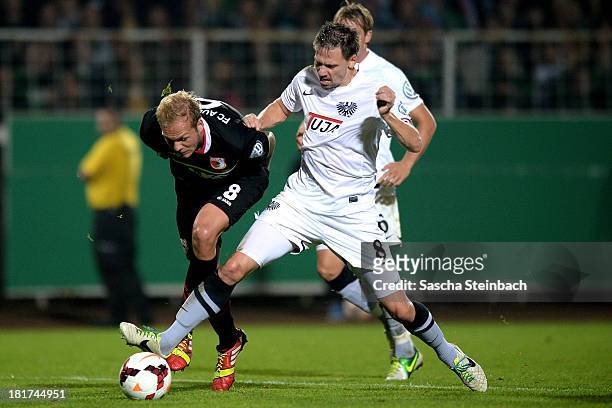 Raphael Holzhaeuser of Augsburg and Stefan Kuehne of Muenster battle for the ball during DFB Cup second round match between Preussen Muenster and FC...