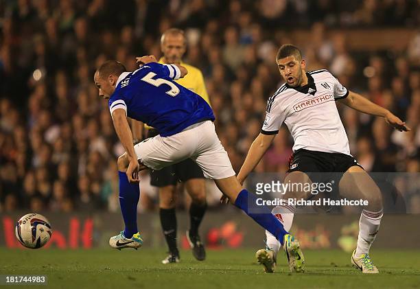 John Heitinga of Everton is tripped by Adel Taarabt of Fulham during the Captial One Cup Third Round match between Fulham and Everton at Craven...
