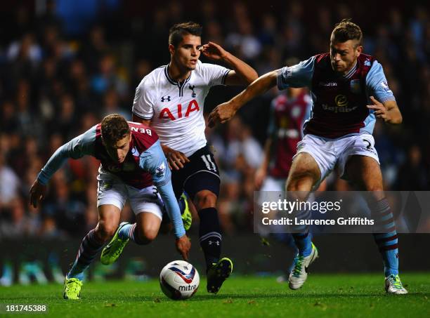 Erik Lamela of Tottenham Hotspur battles with Joe Bennett and Nathan Baker of Aston Villa during the Capital One Cup third round match between Aston...