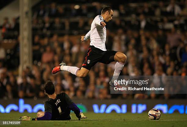 Dimitar Berbatov of Fulham jumps over goalkeeper Joel Robles of Everton during the Captial One Cup Third Round match between Fulham and Everton at...