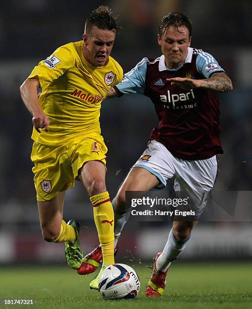 Craig Noone of Cardiff City battles for the ball with Matt Taylor of West Ham during the Capital One Cup third round match between West Ham United...