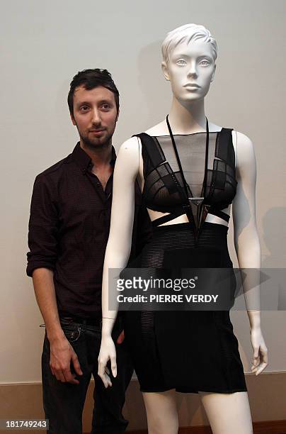 Belgian designer Anthony Vaccarello stands with one of his creations during the autumn-winter 2010 pret-a-porter collection show on March 2, 2010 in...