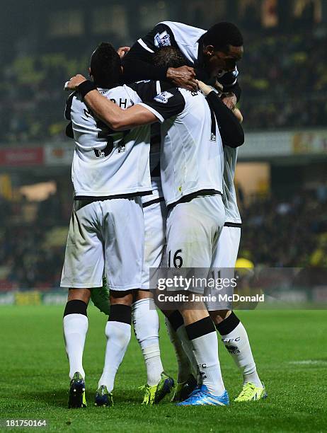 Gary Hooper of Norwich City celebrates with team mates as he scores their third goal during the Capital One Cup Third Round match between Watford and...