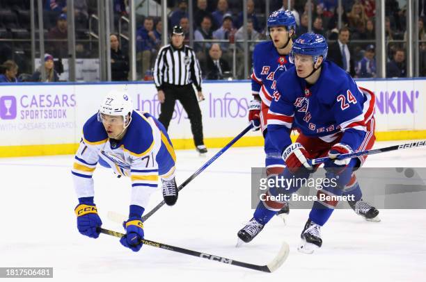 Kaapo Kakko of the New York Rangers trips up JJ Peterka of the Buffalo Sabres during the first period at Madison Square Garden on November 27, 2023...