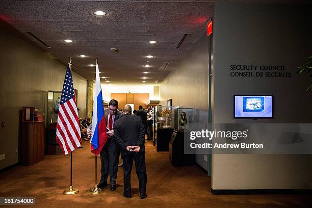 Man adjusts the Russian flag prior to a bilateral meeting between the United States and Russia during the 68th United Nations General Assembly on...