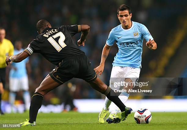 Marcos Lopes of Manchester City takes on Emmerson Boyce of Wigan Athletic during the Capital One Cup third round match between Manchester City and...