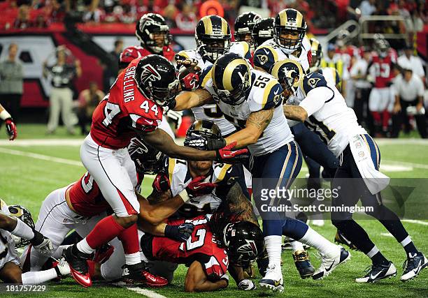 Jason Snelling of the Atlanta Falcons blocks against James Laurinaitis of the St. Louis Rams at the Georgia Dome on September 15, 2013 in Atlanta,...