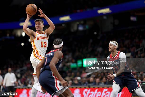 Bogdan Bogdanovic of the Atlanta Hawks passes the ball in front of Bilal Coulibaly of the Washington Wizards in the first half at Capital One Arena...