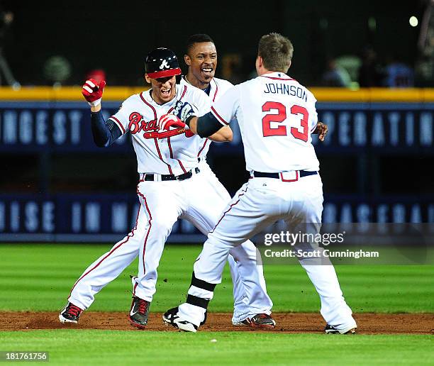 Andrelton Simmons of the Atlanta Braves celebrates with Chris Johnson and B. J. Upton after knocking in the game-winning run in the 9th inning...