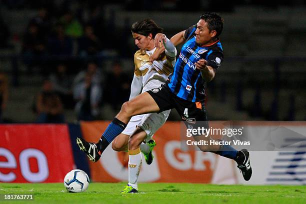 Carlos Orrantia of Pumas struggles for the ball with Dionicio Escalante of Queretaro during a match between Pumas and Queretaro as part of the Copa...