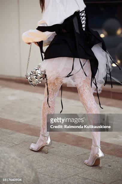 Guest wears white lace tights, white tutu or tule skirt, black vest, white shirt, and big pearl necklace during the Tashkent Fashion Week 2023 on...