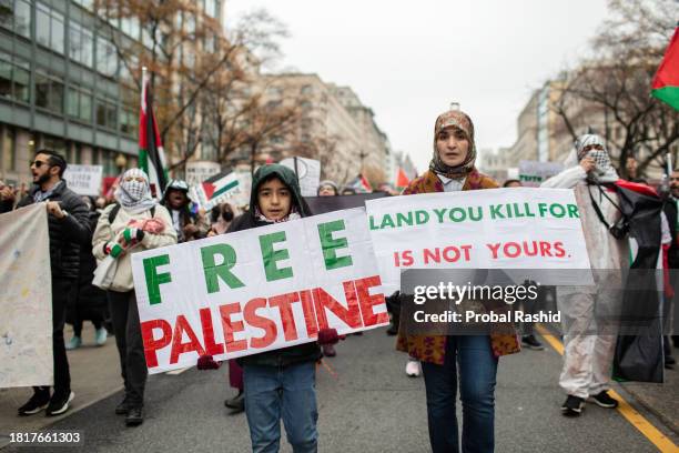 Mother and son holding Palestinian signs, join in a demonstration. Pro-Palestinian demonstrators gather at Lafayette Park near the White House and...