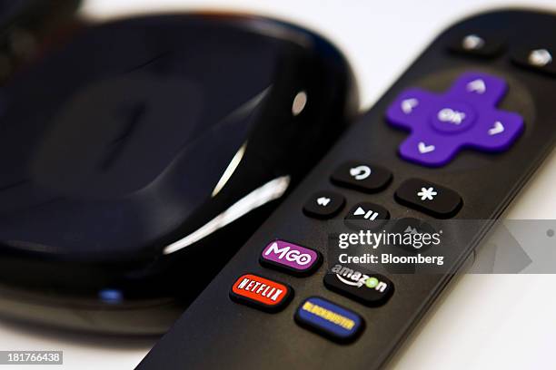The Roku 1 television streaming player and remote control featuring buttons for M-GO, Netflix, Blockbuster and Amazon are arranged for a photograph...