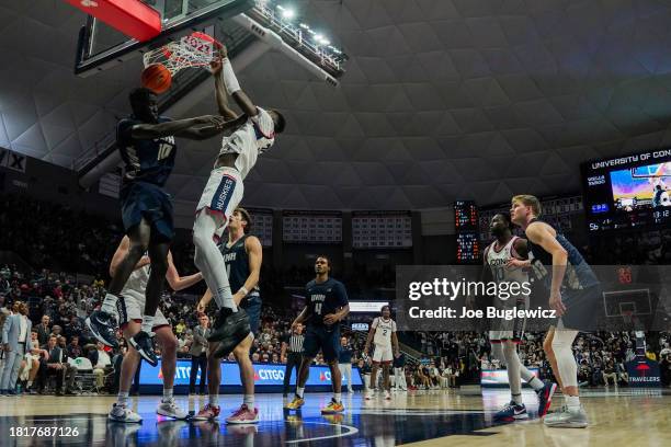 Samson Johnson of the Connecticut Huskies dunks over Paul Gakmar of the New Hampshire Wildcats during the second half at the Harry A. Gampel Pavilion...