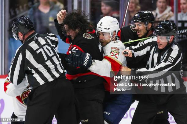 Travis Hamonic of the Ottawa Senators pulls Sam Bennett of the Florida Panthers off teammate Zack MacEwen during a third period scrum at Canadian...