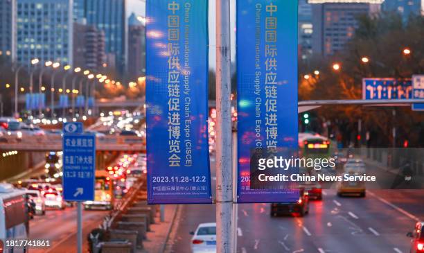 Posters promoting the upcoming first China International Supply Chain Expo hang on the lampposts on November 27, 2023 in Beijing, China. The first...