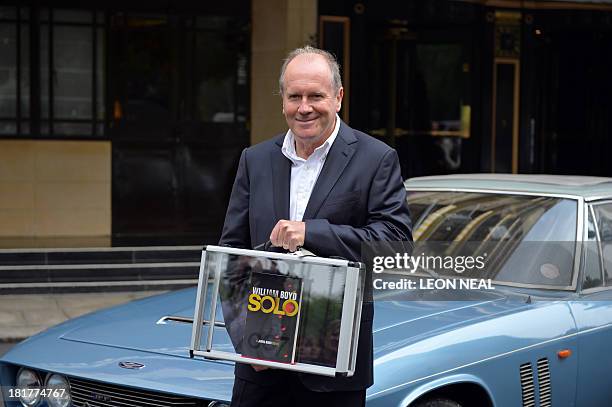 British author William Boyd poses with his new James Bond novel "Solo" during a photo call a day ahead of its release in central London on September...