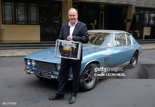 British author William Boyd poses with his new James Bond novel "Solo" during a photo call a day ahead of its release in central London on September...