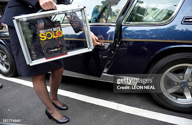 British Airways ambassador Helena Flynn holds British author William Boyd's new James Bond novel "Solo" as she enters a Jensen car during a photo...