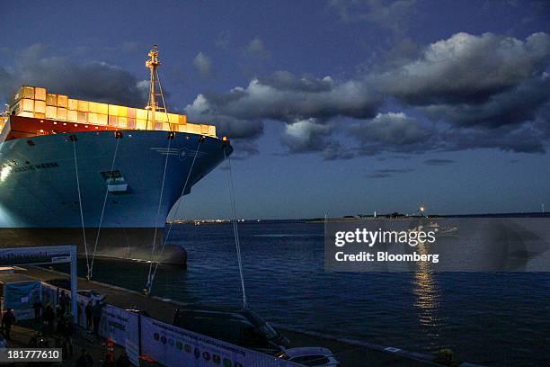 Shipping containers stand illuminated at night on the prow of the Majestic Maersk Triple E class ship, one of the world's largest vessels, operated...