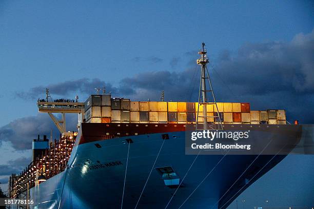 Shipping containers stand illuminated at night on the prow of the Majestic Maersk Triple E class ship, one of the world's largest vessels, operated...