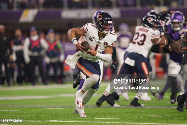 Quarterback Justin Fields of the Chicago Bears runs with the ball during an NFL football game against the Minnesota Vikings at U.S. Bank Stadium on...