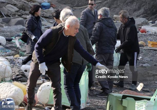 Ambassador to Japan Rahm Emanuel picks up plastic litter during a beach clean-up in Tsushima, Nagasaki Prefecture, southwestern Japan, on Dec. 3,...