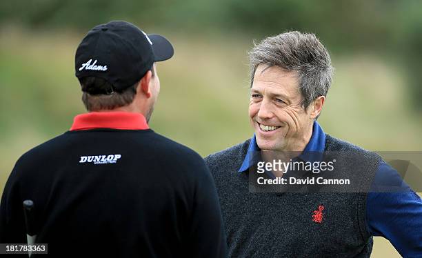 Actor Hugh Grant of Englandwith his partner David Howell of England during a practice round at Kingsbarns for the 2013 Alfred Dunhill Links...