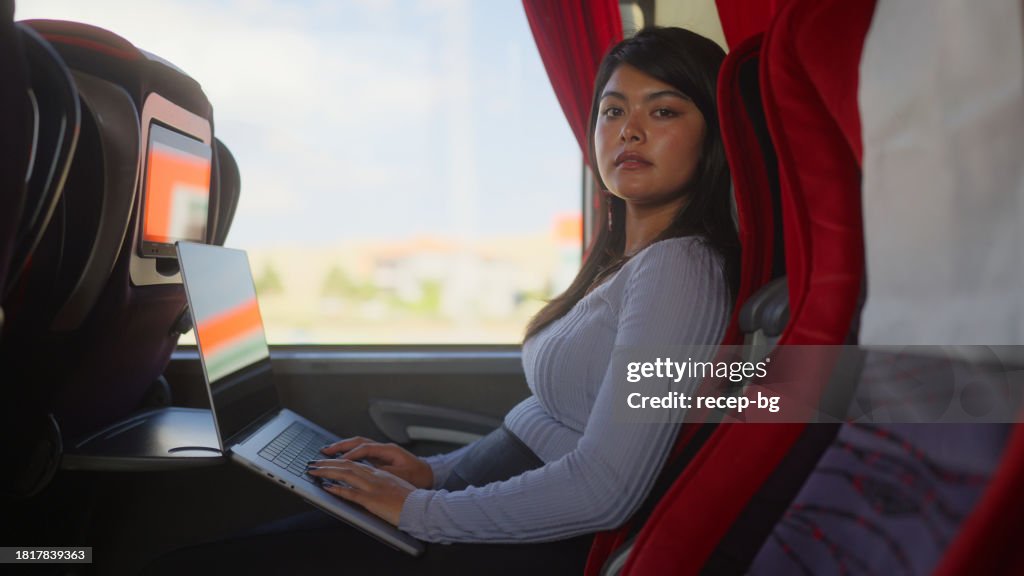 Reisende benutzt ihren Laptop im Bus