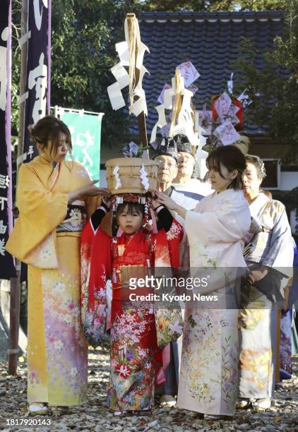 Girl carries a rice tub on her head during the Nenneko Matsuri, a festival to pray for the growth of children and a bountiful harvest, at Konoha...