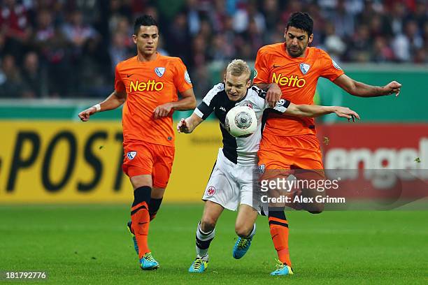 Sebastian Rode of Frankfurt is challenged by Mirkan Aydin and Danny Latza of Bochum during the DFB Cup second round match between Eintracht Frankfurt...