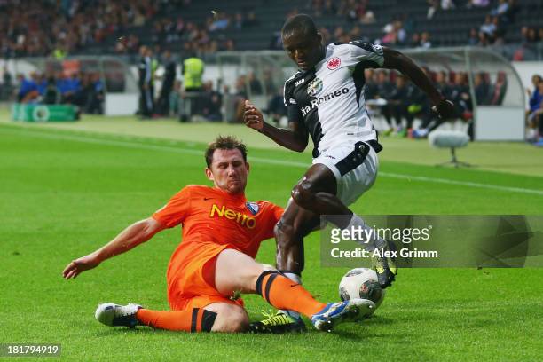 Constant Djakpa of Frankfurt is challenged by Paul Freier of Bochum during the DFB Cup second round match between Eintracht Frankfurt and VfL Bochum...