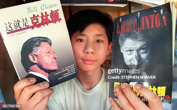 Book shop attendant displays 23 June two recent books about US President Bill Clinton recently published in Beijing, a day before Clinton arrives in...