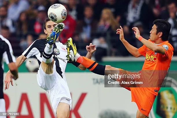 Johannes Flum of Frankfurt is challenged by Yusuke Tasaka of Bochum during the DFB Cup second round match between Eintracht Frankfurt and VfL Bochum...