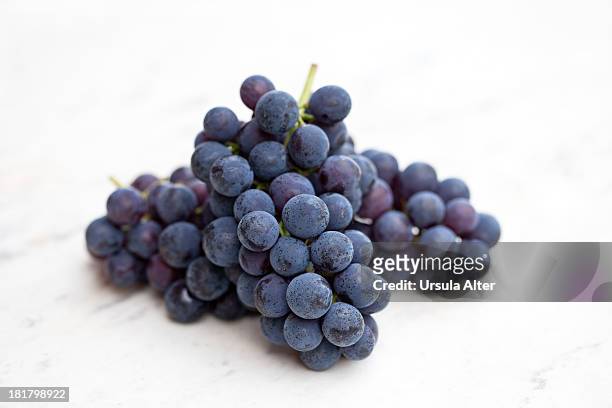 blue grape on white marble - red grapes stock pictures, royalty-free photos & images