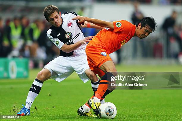 Yusuke Tasaka of Bochum is challenged by Sebastian Jung of Frankfurt during the DFB Cup second round match between Eintracht Frankfurt and VfL Bochum...