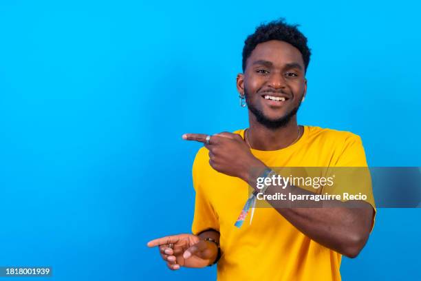 happy african young man pointing at an empty space - announcement message stock pictures, royalty-free photos & images