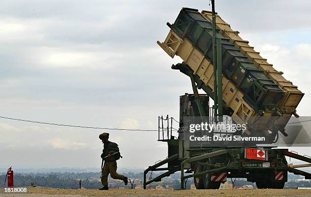 An Israeli soldier runs from a Patriot missile launcher February 27, 2003 as the anti-aircraft and anti-ballistic missile missile is ready to launch...