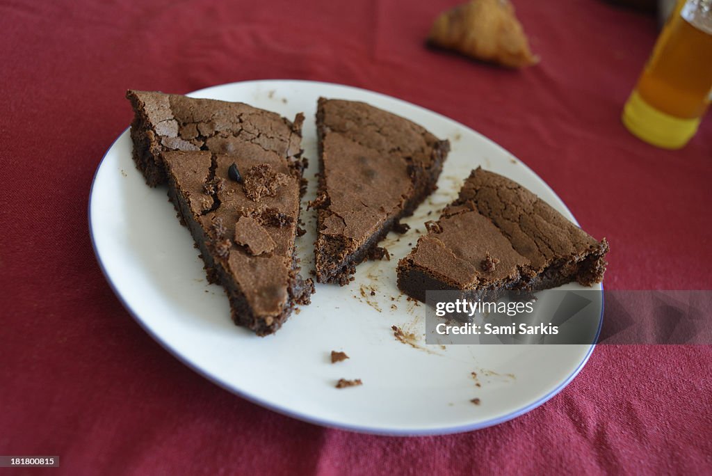 Chocolate brownie and crumbs in plate on table