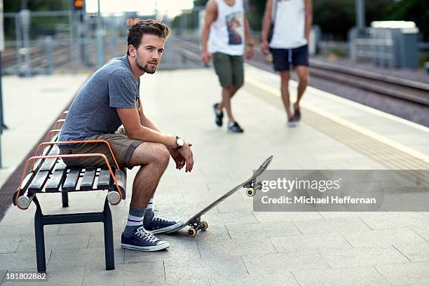 young man waiting at train station - michael sit stock pictures, royalty-free photos & images
