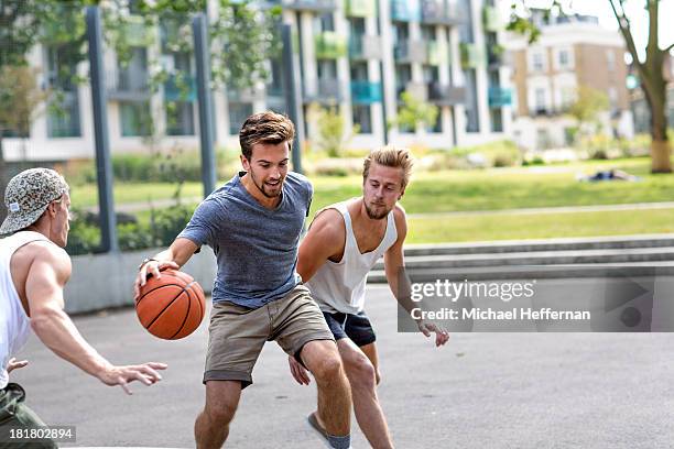 three young men playing basketball - dribbling sport foto e immagini stock