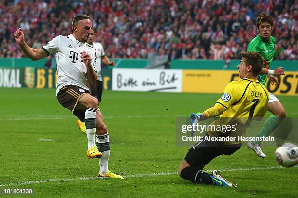 Franck Ribery of Muenchen scores the 4rd team goal against Hiroki Sakai of Hannover and his keeper Ron-Robert Zieler during the DFB Cup match between...