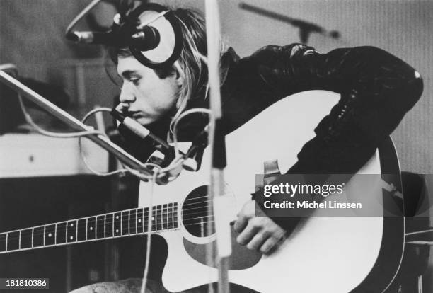 Singer-songwriter and guitarist Kurt Cobain , of American grunge band Nirvana, playing a Takamine acoustic guitar during a recording session at...