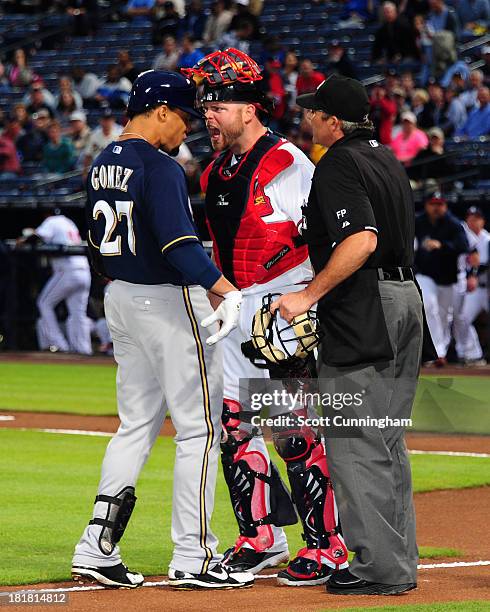 Carlos Gomez of the Milwaukee Brewers is confranted at home plate by Brian McCann of the Atlanta Braves after hitting a first inning home run at...