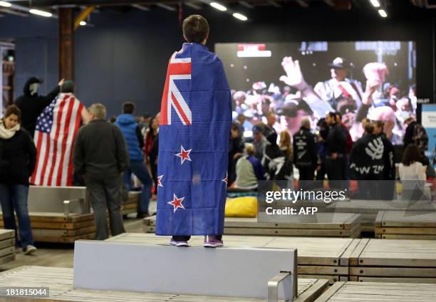 Fans of Team New Zealand show their support as they watch racing in the America's Cup at a venue set up in downtown Auckland with large television...