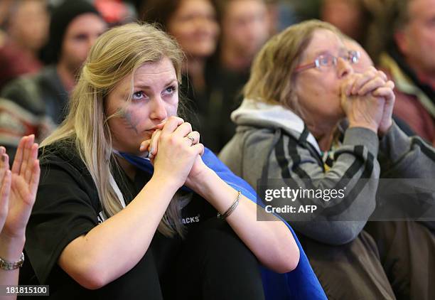 Fans of Team New Zealand show their support as they watch racing in the America's Cup at a venue set up in downtown Auckland with large television...