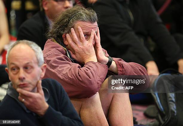 Fans of Team New Zealand react as they watch racing in the America's Cup at a venue set up in downtown Auckland with large television screens on...