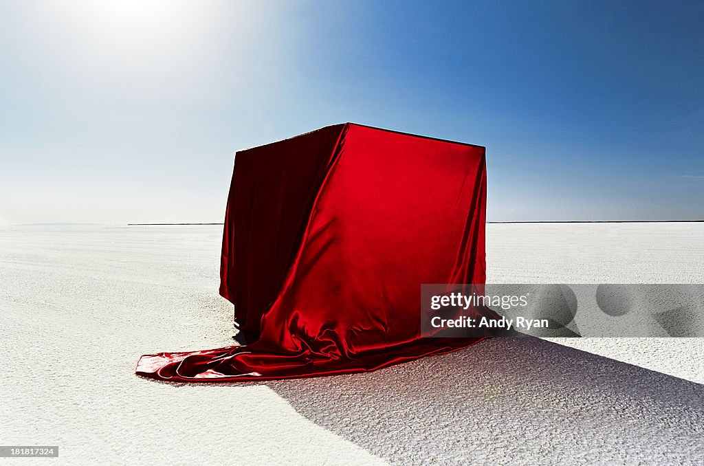 Box covered in red fabric on salt flats.